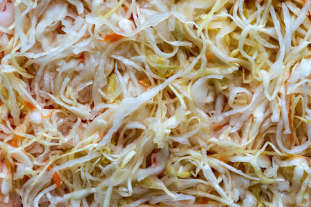 cabbage shredded and fermented with carrots for a background and texture closeup of motley colorの写真素材