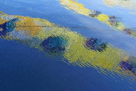 background and texture from abstract corrugated and wavy reflection in water of color spotsの写真素材