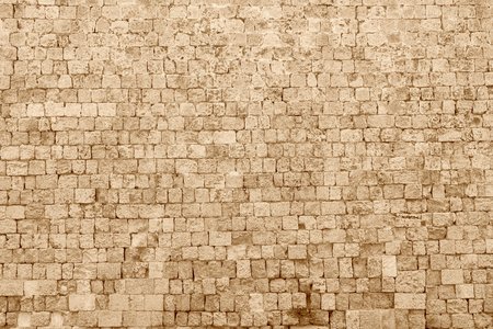 the textured fragment of old stone wall of ancient fortress of sepia color for backgroundの写真素材