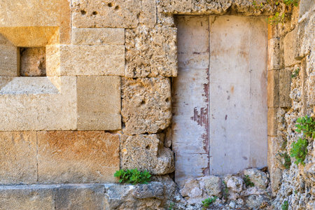 very old door on an ancient stone wallの写真素材