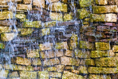 wet stone brick wall with water splashes for the abstract textured backgroundの写真素材