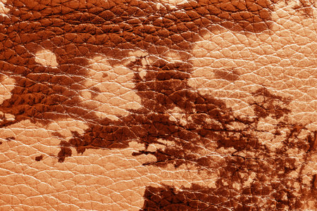 abstract background of rough spotty texture of natural leather closeup red tone