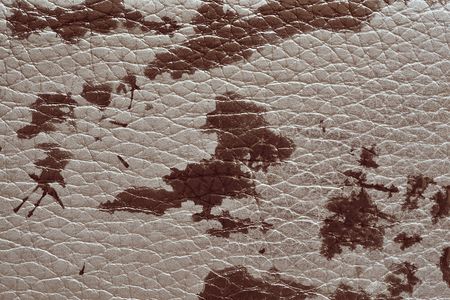 abstract background of rough spotty texture of natural leather closeup burgundy toneの写真素材