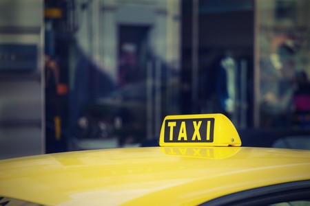 fragment of one yellow car of the taxi with the sign or with a symbol closeup and in the color photo in retro styleの写真素材