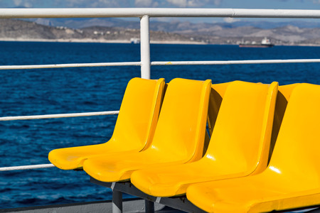 empty yellow seats or bench closeup on the deck of the shipの写真素材