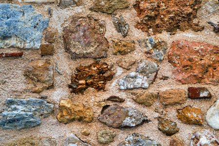 the combined texture of an old stone concrete wall closeupの写真素材