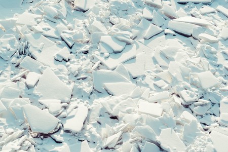 abstract texture of big splinters and pieces of ice and snow of frozen water for a natural background or for wallpaperの写真素材