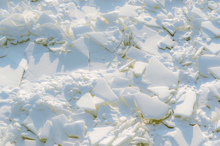 abstract texture of big splinters and pieces of ice and snow of frozen water for a natural background or for wallpaperの写真素材