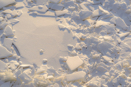 the textured splinters and pieces of broken ice of frozen water and snow in the nature for an abstract natural backgroundの写真素材