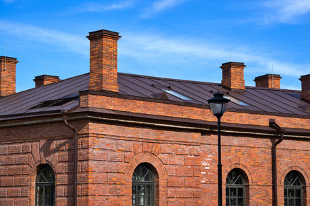 large fragment of the brick vintage house or building and the blue sky with white clouds