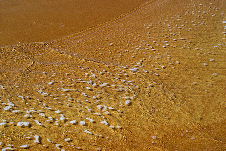 texture of a sandy bottom with water foam for a natural landscape background