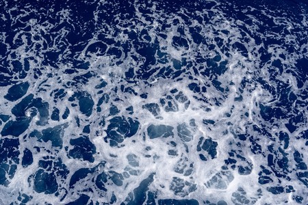 abstract texture of sea white foam on a blue background of sea waterの写真素材