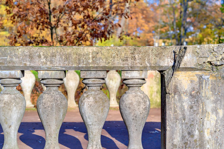old ancient fence or protection with figured rail-posts closeup against the background of an autumn...