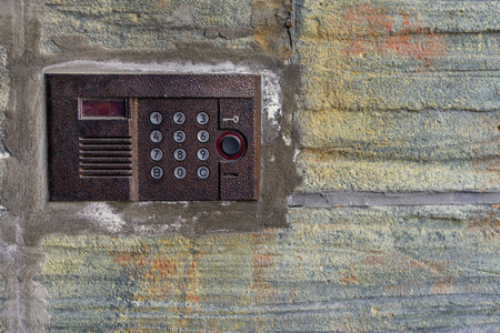 one panel management of the old on-door speakerphone on an old concrete wall closeupの写真素材