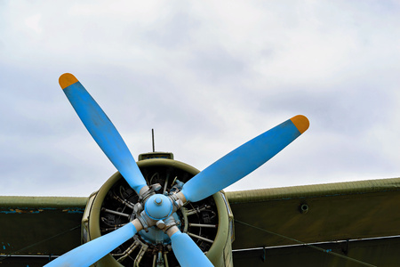 front part of the fuselage of the old military samolyut with the propeller closeup against the background of an empty and clear skyの写真素材