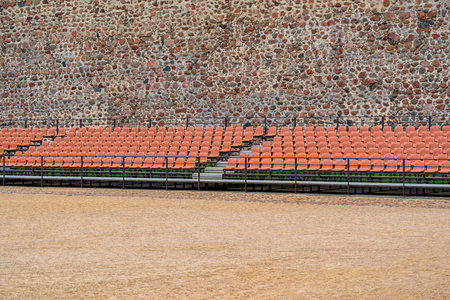 rows of seats for the audience in the foreground outdoors and against the background of an ancient...