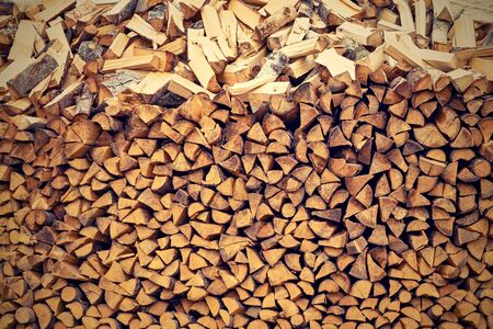 Texture of an end face of wooden firewood in a stack for a background or for wallpaper.の写真素材