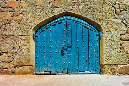 ancient stone wall for vintage background with old wooden gate closeupの写真素材