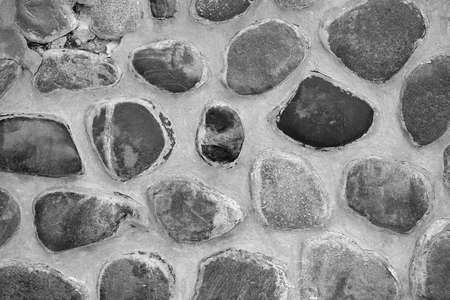 abstract spotted texture of stone and concrete wall close-up for background or wallpaper of monochrome toneの写真素材