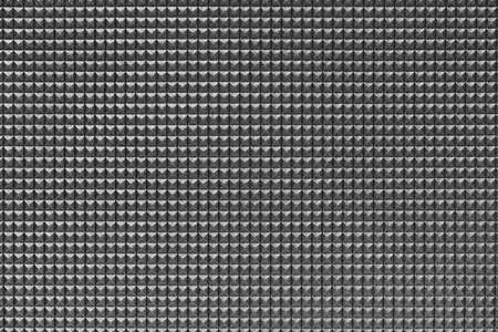granular corrugated texture with small convex pyramids or teeth of regular square shape arranged symmetrically and in even order in horizontal and vertical rowsの写真素材