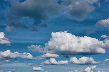 cloudy blue sky with different clouds and one big white cloud in the foregroundの写真素材