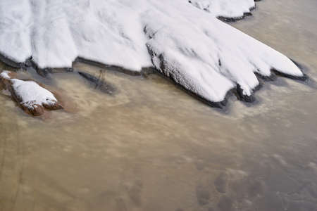 abstract landscape close-up of the winter shore with snow and water for natural backgroundの写真素材