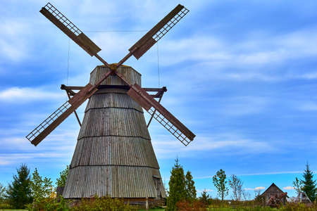 one big ancient wooden windmill closeup against the background of the skyの写真素材