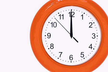 large of orange color analog clock show 12 hours at midnight or noon close-upの写真素材