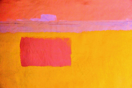 abstract pattern of one red rectangular spot on a yellow plastered wall for background or wallpaperの写真素材