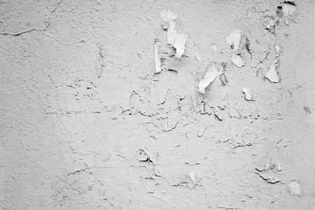 old plastered gray concrete wall surface with fragmentary paper stickers for abstract background or wallpaperの写真素材