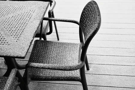 abstract snow-covered parts of the chair and table of black color and closeup outdoors with white snowの写真素材