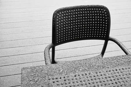 abstract snow-covered parts of the chair and table of black color and closeup outdoors with white snowの写真素材