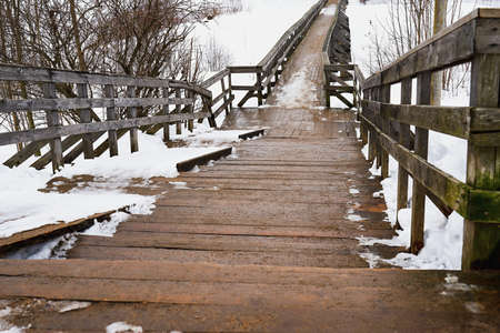 abstract empty old and vintage wooden bridge closeup and snow in winter or springの写真素材