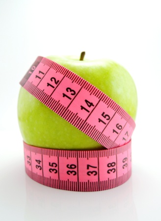 Green apple with pink measuring tapeの写真素材