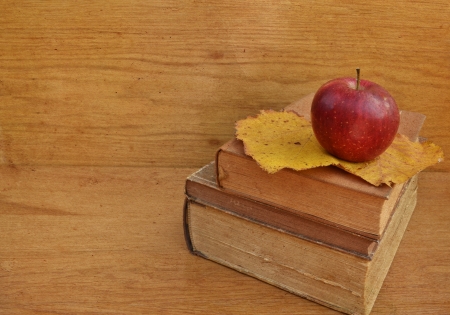 Apple on old books on wooden backgroundの写真素材