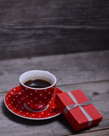 Cup of coffee with present on wooden の写真素材