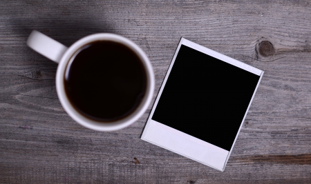 White mug of coffee and photo paperの写真素材