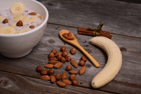 bowl of muesli and millk with fresh banana close up on woodenの写真素材