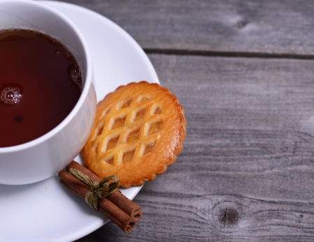 Cookies with cinnamon and cup of tea on wooden backgroundの写真素材