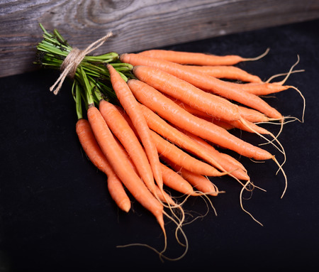 Bunch of fresh carrots on black backgroundの写真素材
