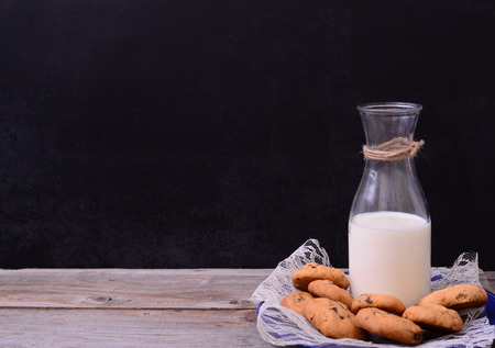 Bottle of milk with cookies on rustic tableの写真素材