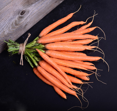 Bunch of fresh carrots on black backgroundの写真素材