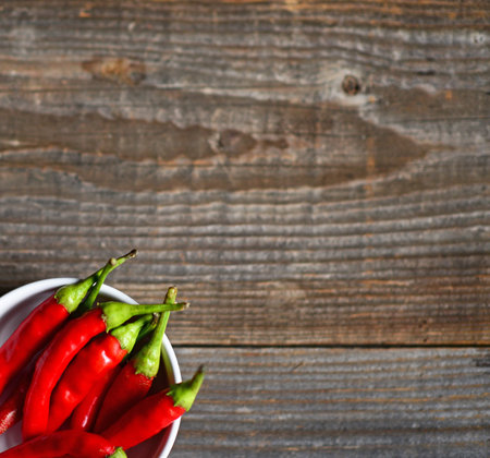 Chilly pepper on the wooden background