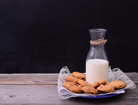 Bottle of milk with cookies on rustic tableの写真素材