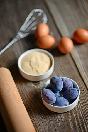 Baking plum cake on old wooden table.の写真素材
