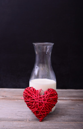 Bottle of milk from the heart on black backgroundの写真素材