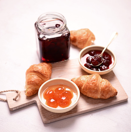 Breakfast with fresh croissants and jam on white backgroundの写真素材