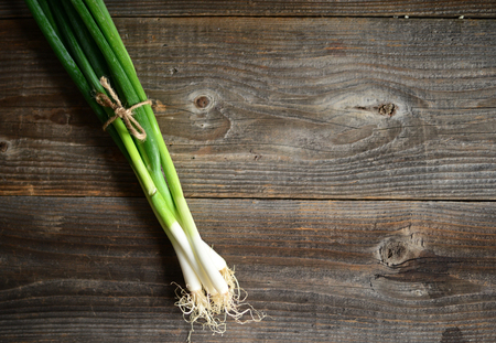 Bunch of spring onions on wood backgroundの写真素材