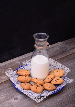 Bottle of milk with cookies on rustic tableの写真素材