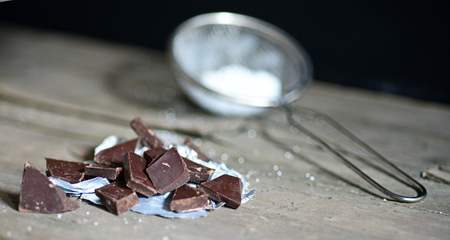 Broken chocolate bar and spices on wooden tableの写真素材